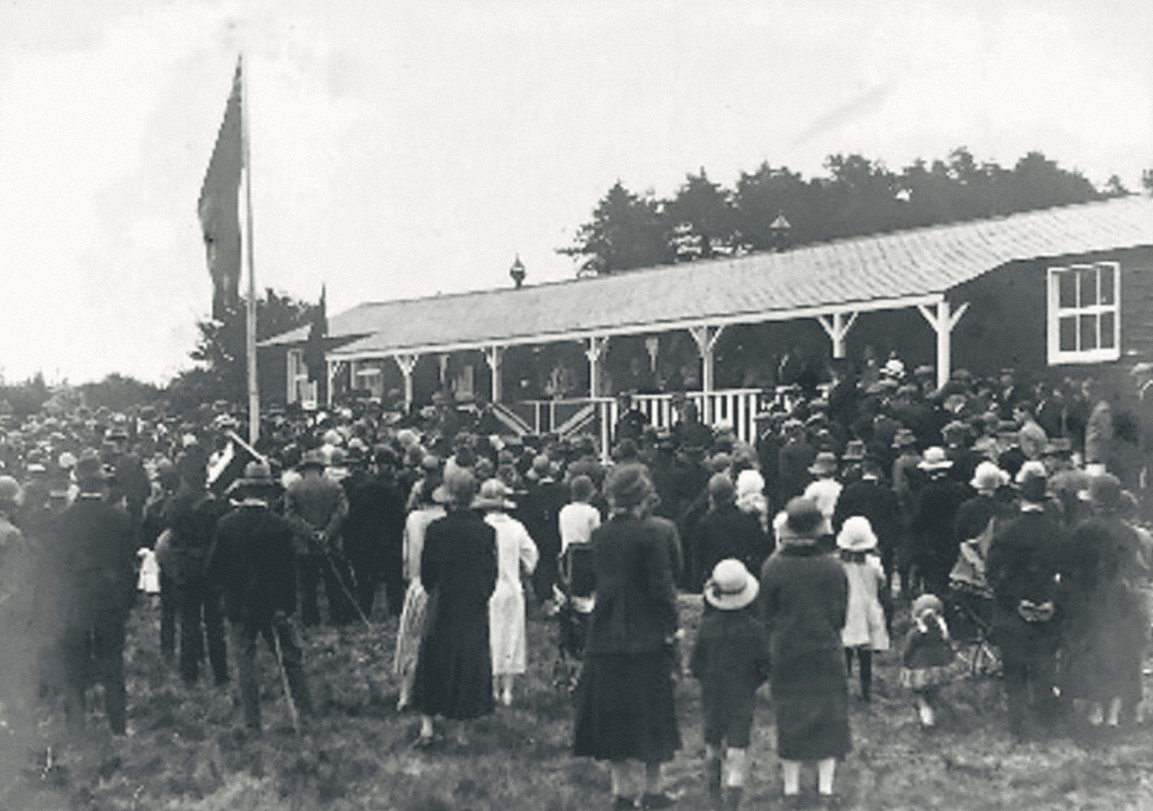 Archive photograph: a large crowd of villagers gathered outside the Hub building in the early twentieth century